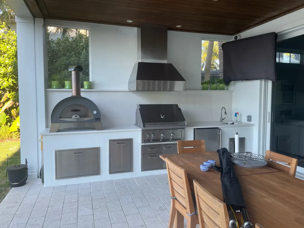 Outdoor kitchen attached to house with pizza oven