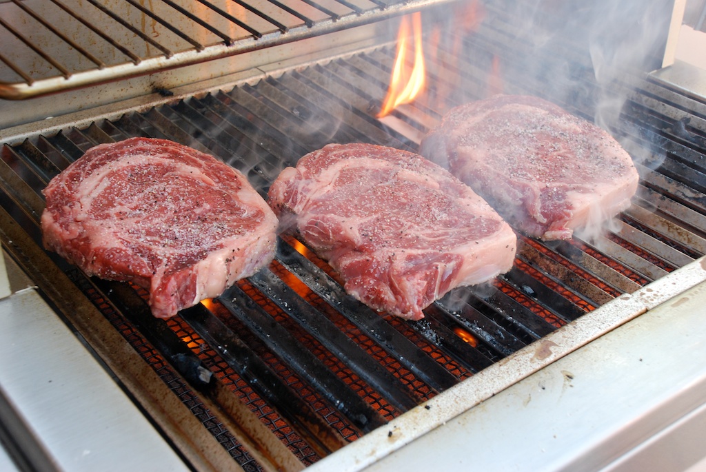 ribeye steaks on a gas grill