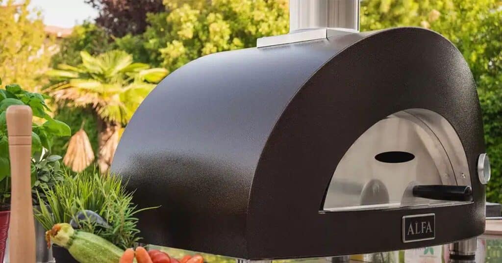 Modern Backyard Pizza Oven Installation – Paradise Outdoor Kitchens - Paradise Outdoor Kitchens A modern outdoor pizza oven installed in a Florida backyard surrounded by fresh herbs and vegetables.