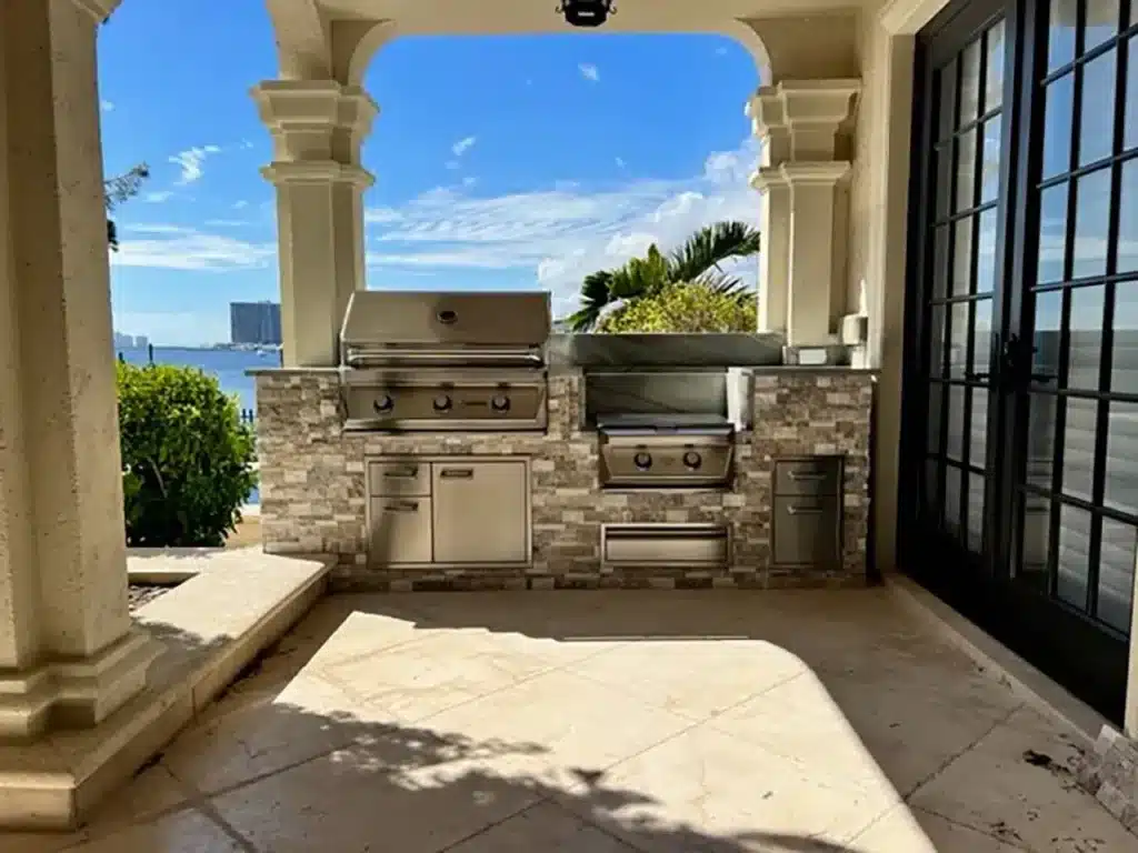 stone outdoor kitchen under covered pergola south florida